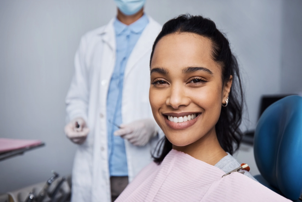 A woman smiles while standing in front of a dentist.