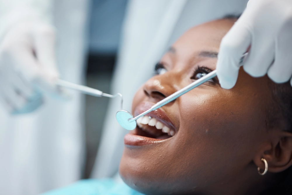 A woman is getting her teeth cleaned by dentist.